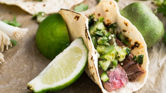 asian mother is teaching her son to cut vegetable at home